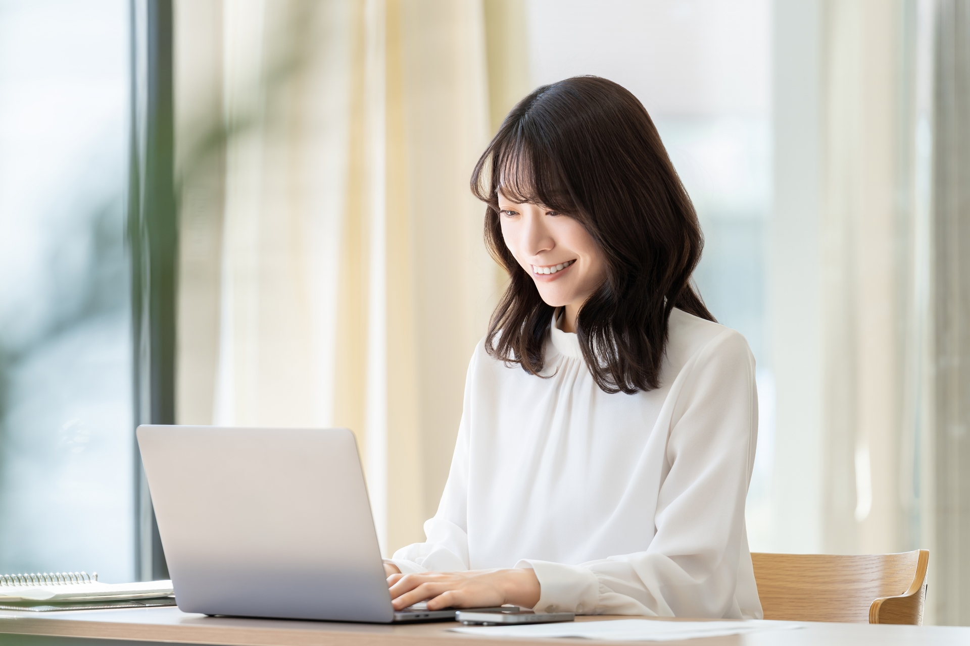 PCで仕事をする笑顔の女性
